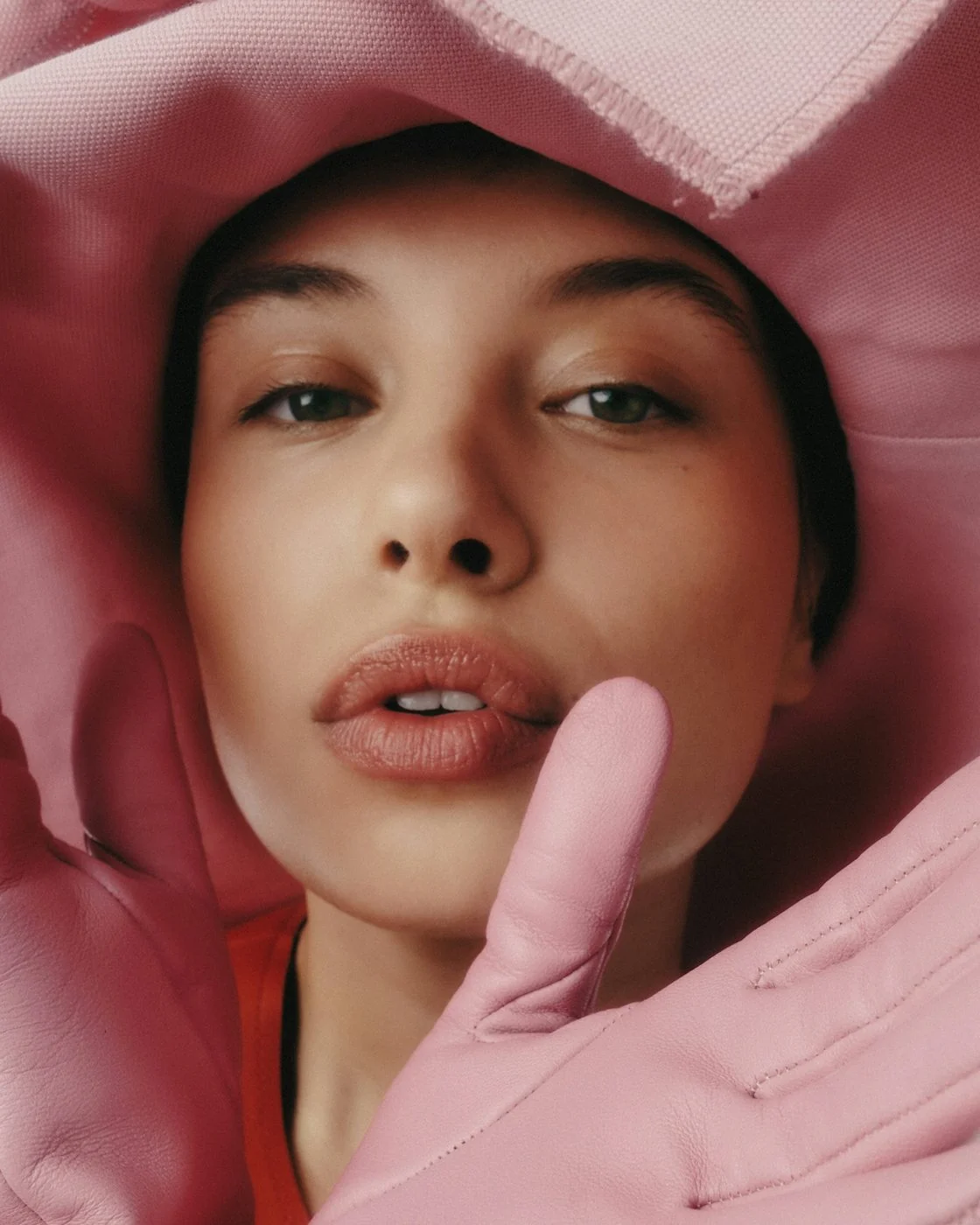 Portrait of a model in a pink hood and gloves