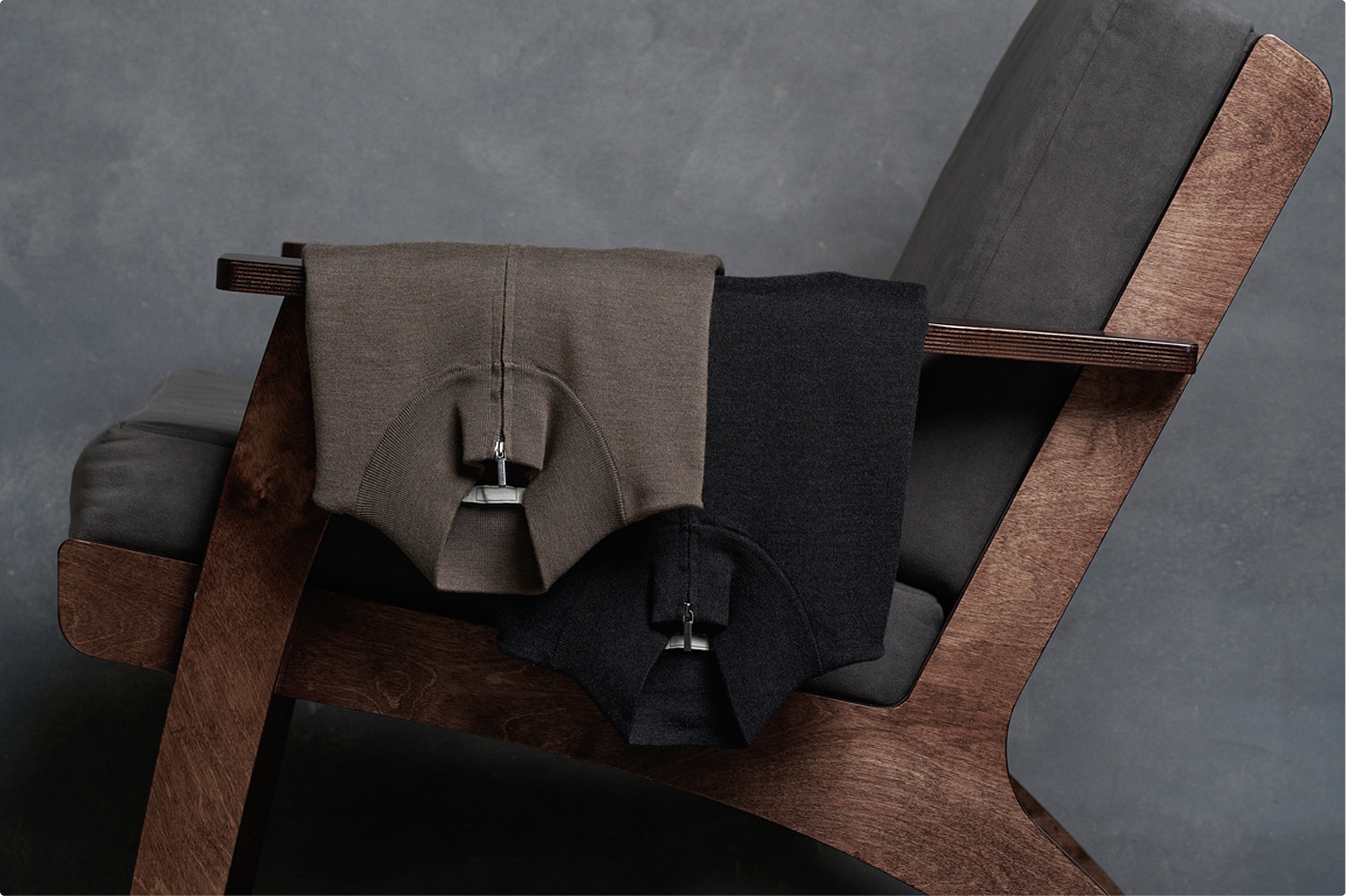 Neatly folded polo shirts arranged on a mid-century wooden chair